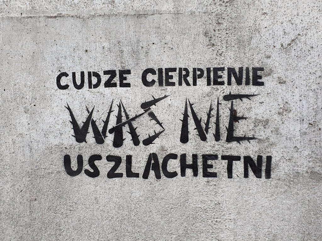 Napis na murze Cudze cierpienie Was nie uszlachetni